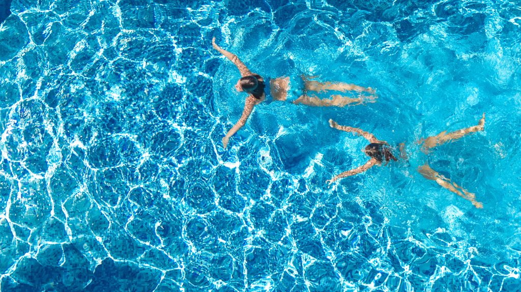 Two people swimming in a madison pool